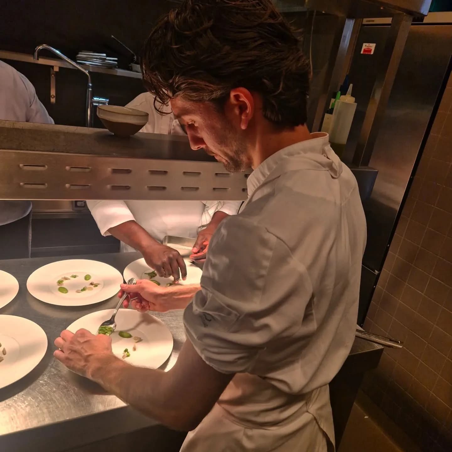 Le chef Cem Comak termine les assiettes au passe