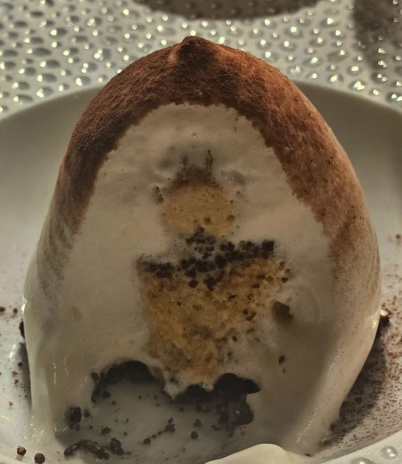 Un dessert en dôme sur une assiette texturée