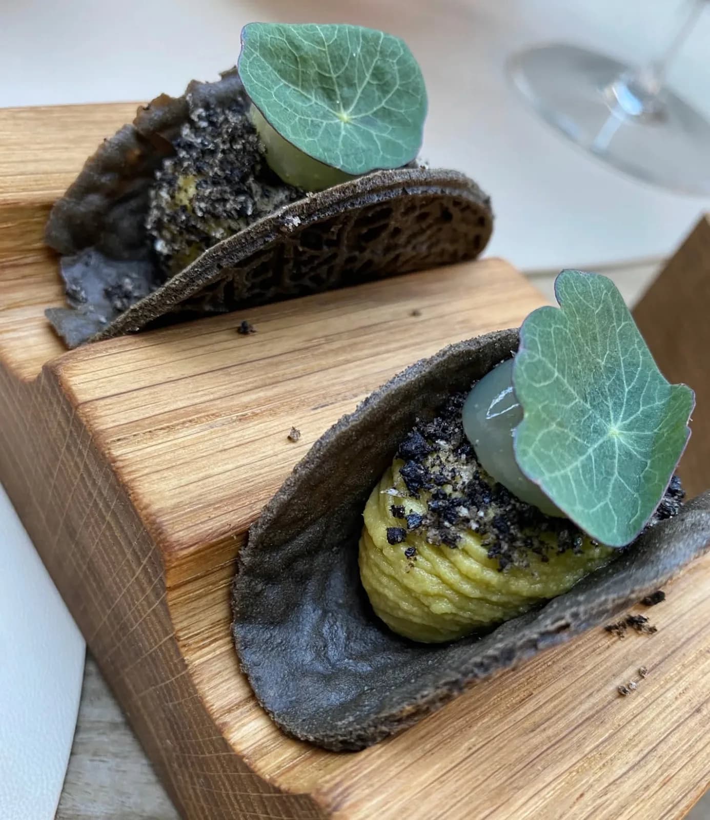 Canapés en coques sombres garnis de feuilles de capucine